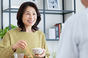 食事を味わい、笑顔で会話する女性